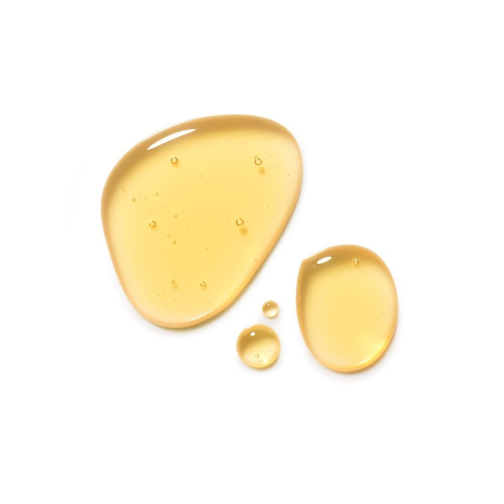 Gocce di olio corpo giallo su sfondo bianco.