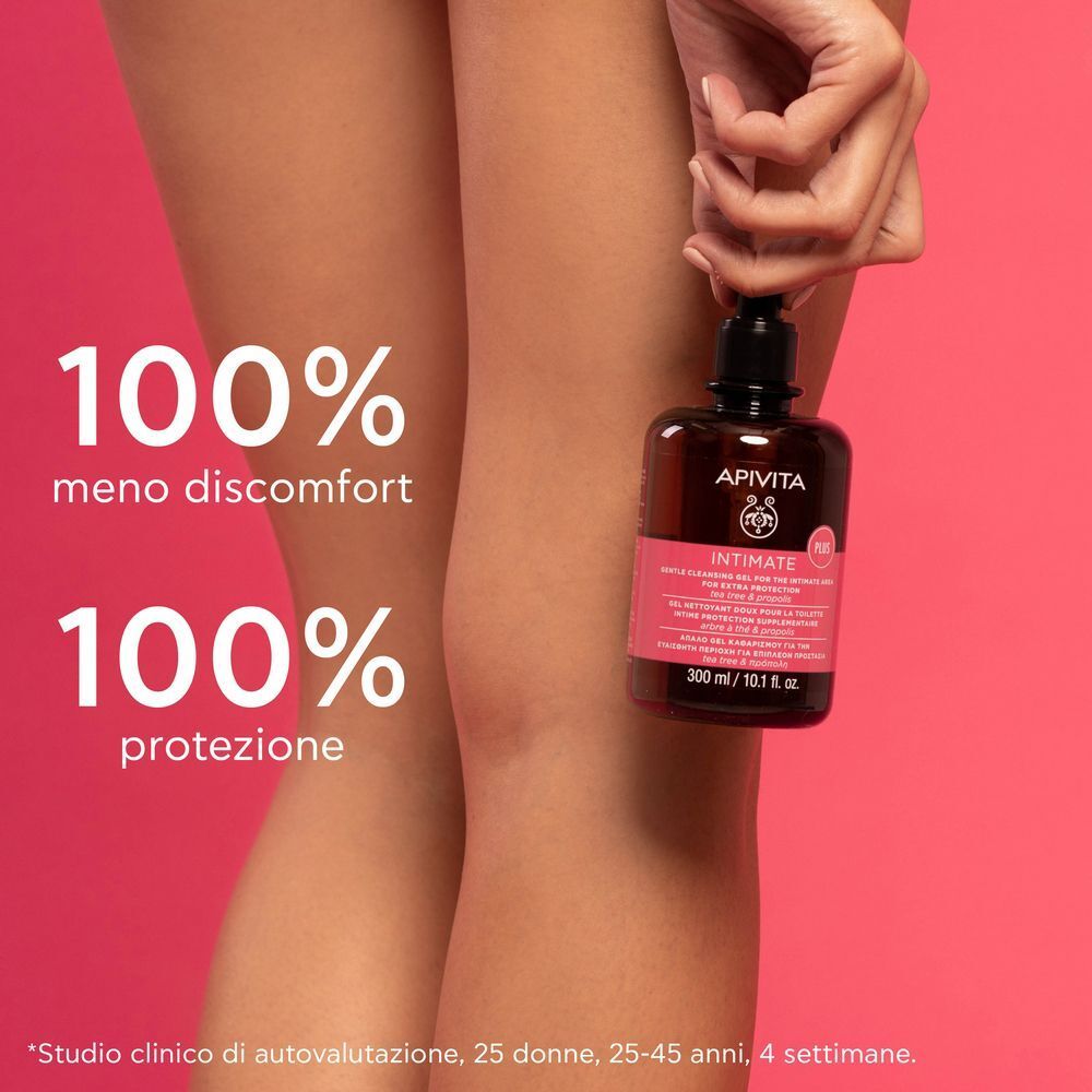 Gel detergente Apivita Intimate Plus tenuto da una mano, gambe sullo sfondo.