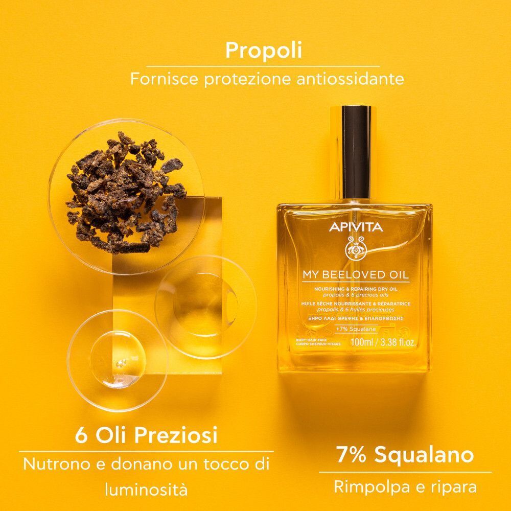 Flacone APIVITA My Beeloved Oil accanto a pezzi di propoli e coppette con oli. Testo: Propoli per protezione antiossidante. 6 Oli Preziosi nutrono e donano luminosità. 7% Squalano.