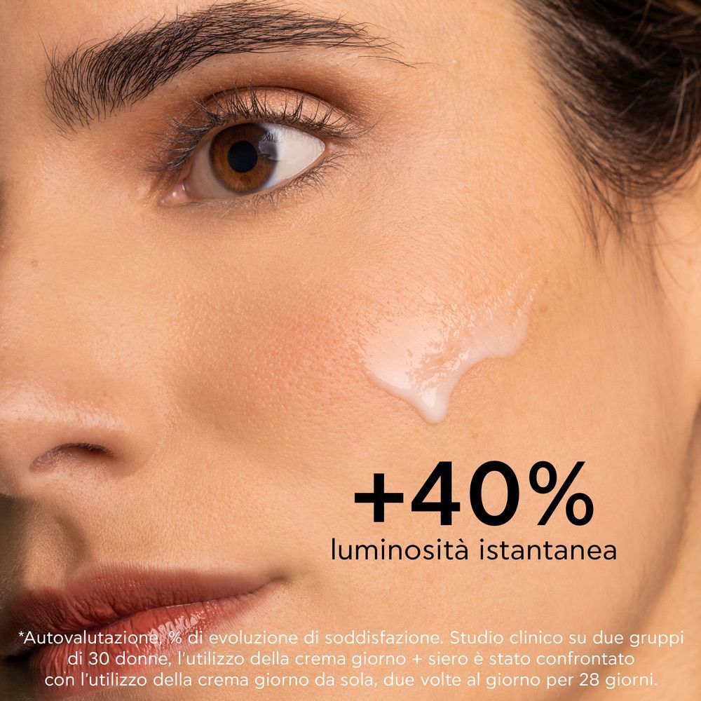 Primo piano di un viso con texture di siero applicata. +40% di luminosità istantanea.