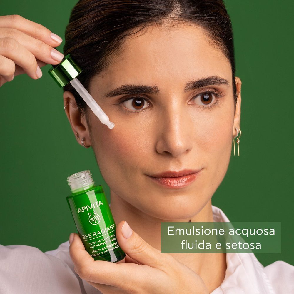 Donna tiene pipetta Apivita Bee Radiant Siero. Emulsione acquosa fluida e setosa.