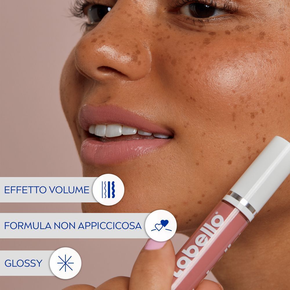 Primo piano di donna con Labello Lip Oil Glossy Dress Nude. Testo: Effetto volume, formula non appiccicosa.