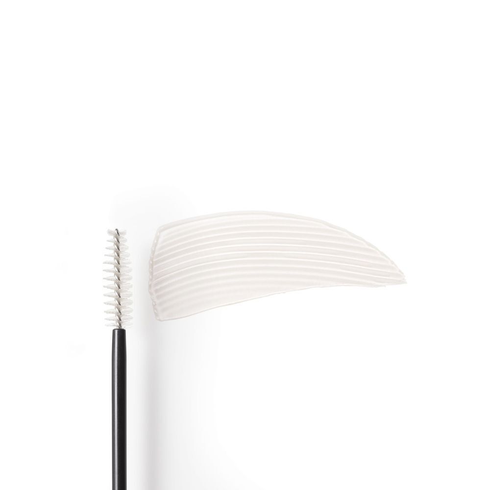 Applicatore e una striscia di gel trasparente Dr. Hauschka Brow & Lash su sfondo bianco.