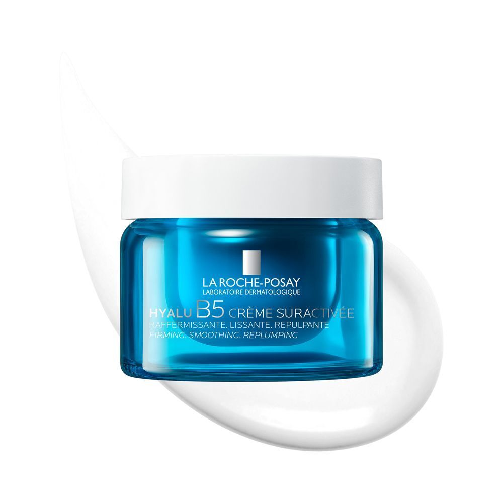 Crema La Roche-Posay Hyalu B5 in un barattolo di vetro blu con coperchio bianco, circondata da una scia di crema bianca.