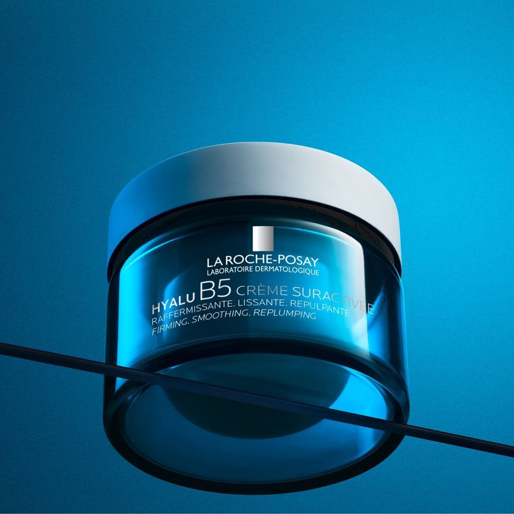 Crema La Roche-Posay Hyalu B5 in un barattolo di vetro blu con coperchio bianco, su sfondo blu.