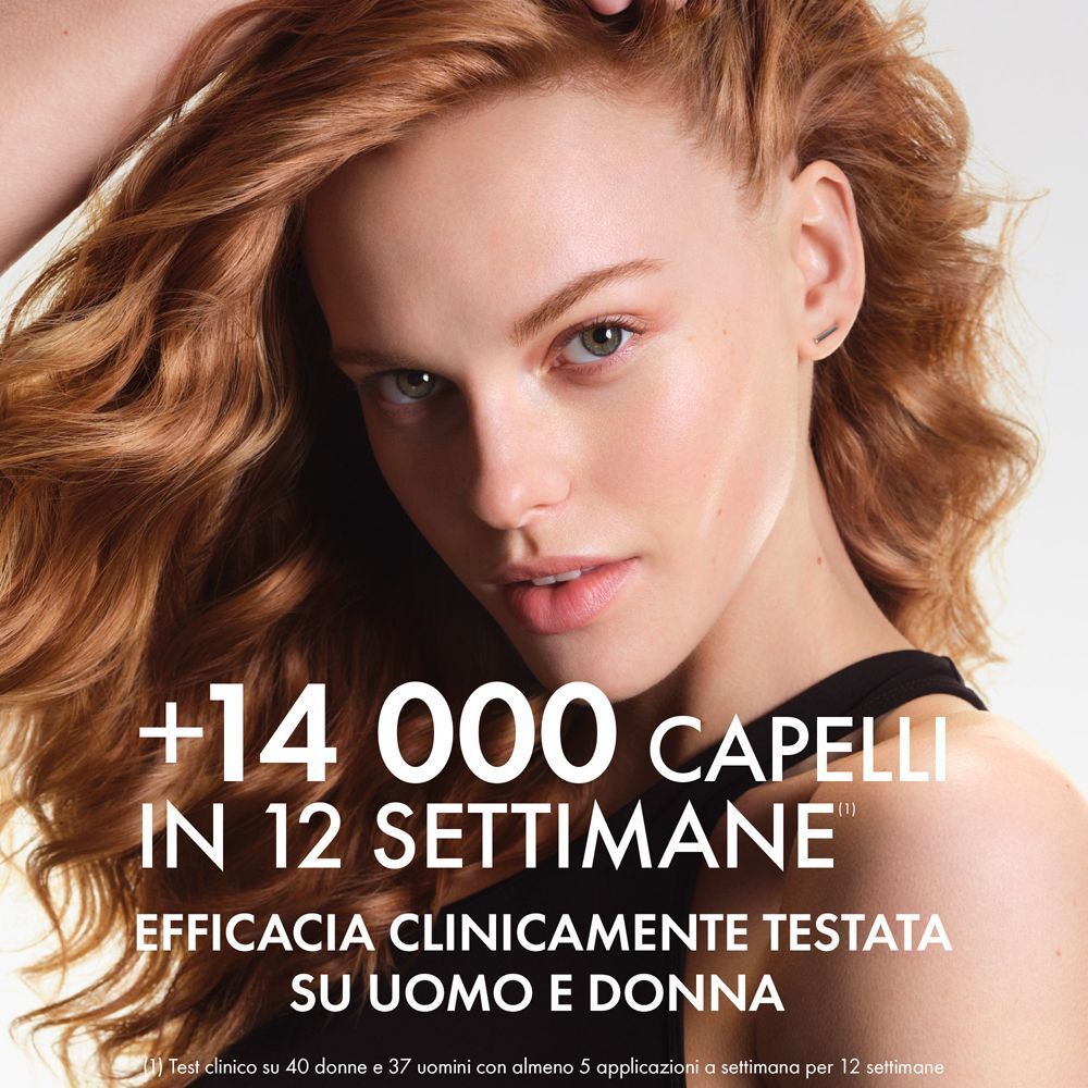 Donna con lunghi capelli rossi guarda avanti. Testo nell'immagine: "+14 000 CAPELLI IN 12 SETTIMANE" e "EFFICACIA CLINICAMENTE TESTATA SU UOMO E DONNA".