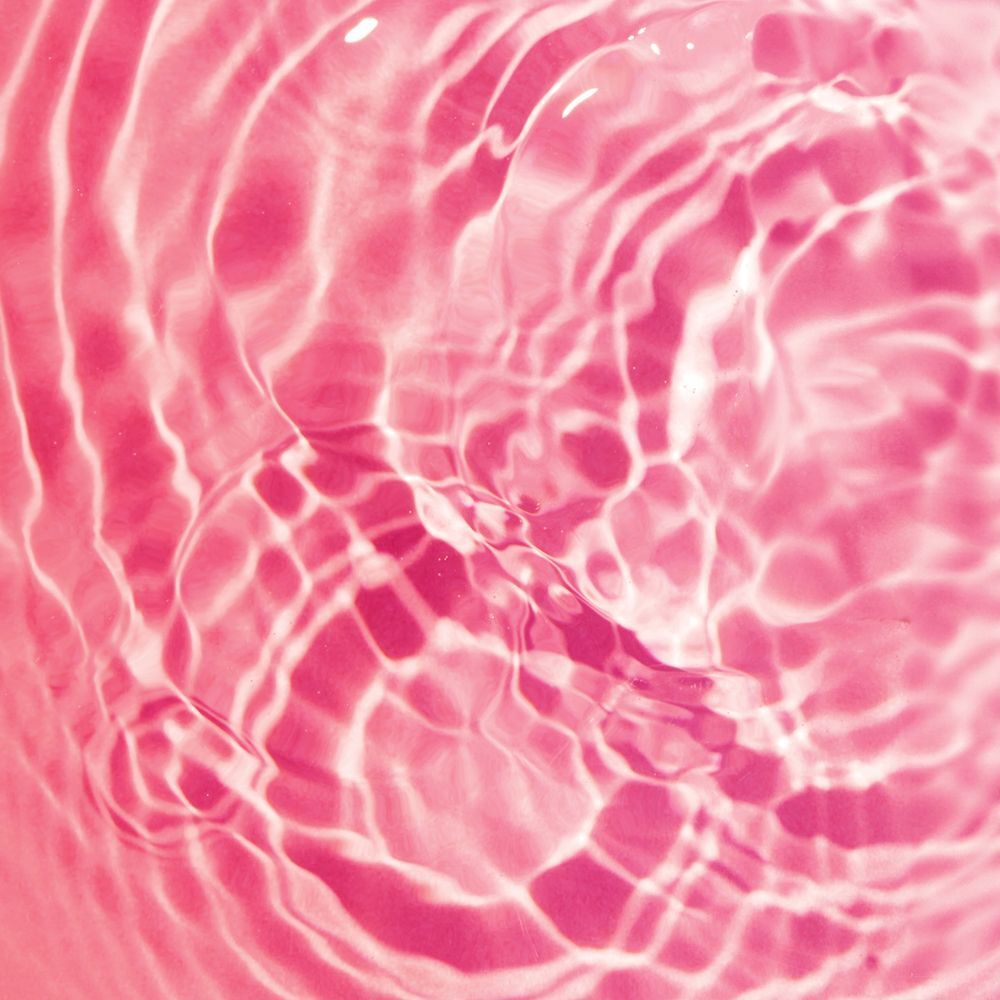 Liquido rosa ondulato con riflessi luminosi che suggeriscono freschezza.