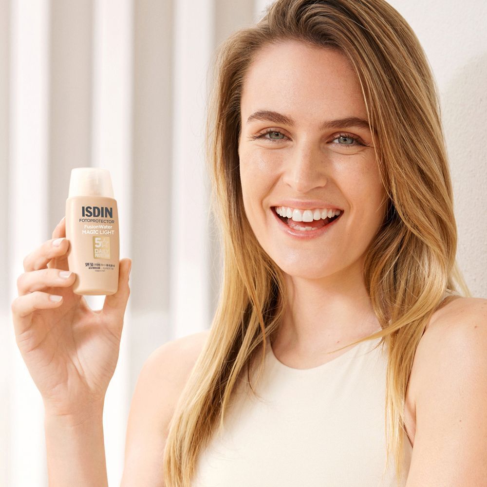 Donna che tiene ISDIN Fotoprotector Fusion Water Magic Light SPF50.