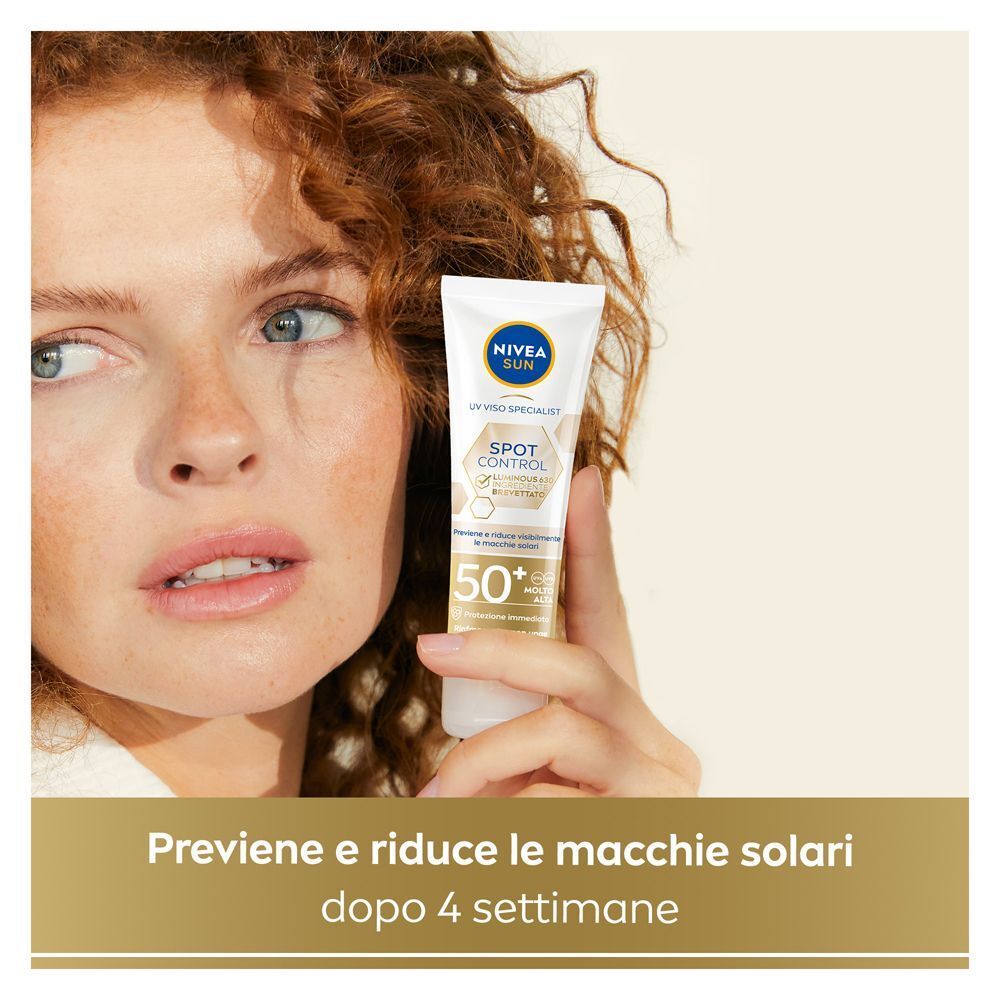 Donna tiene Nivea Sun Anti-Macchie Luminous630 Fluido Solare Viso, FP 50+. Riduce le macchie solari dopo 4 settimane.