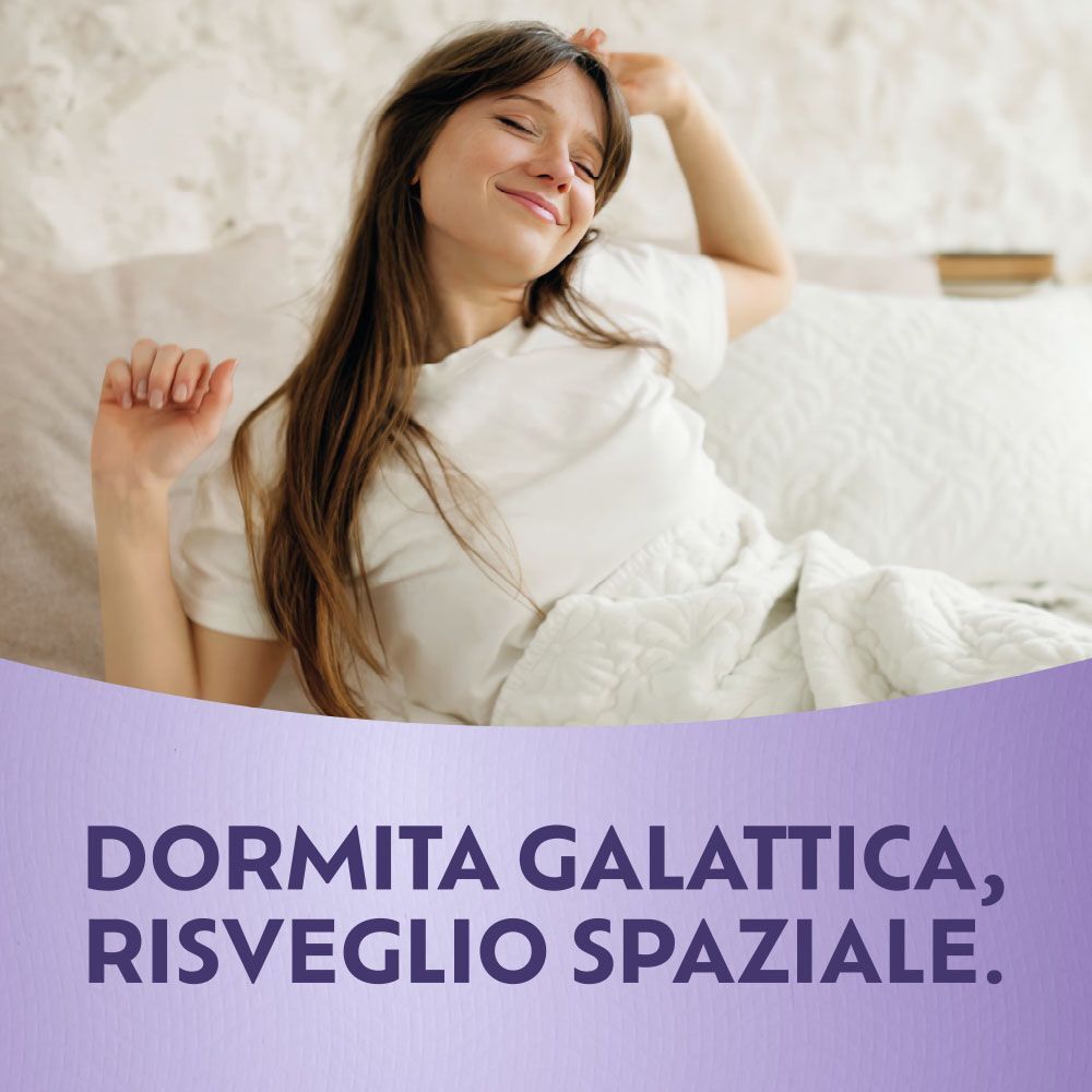 Giovane donna si stiracchia appena sveglia a letto.