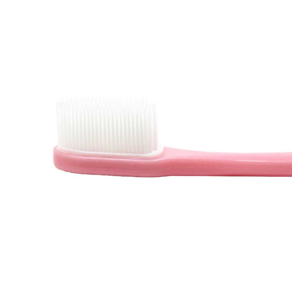 Primo piano della testina bianca di uno spazzolino rosa.