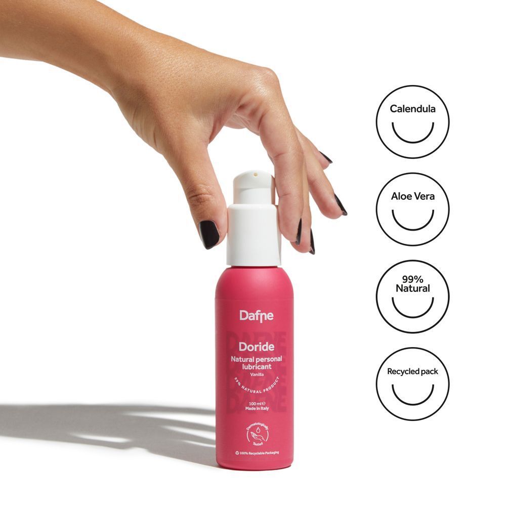 Mano tiene flacone di lubrificante Dafne Doride. Icone: Calendula, Aloe Vera, 99% naturale, confezione riciclata.