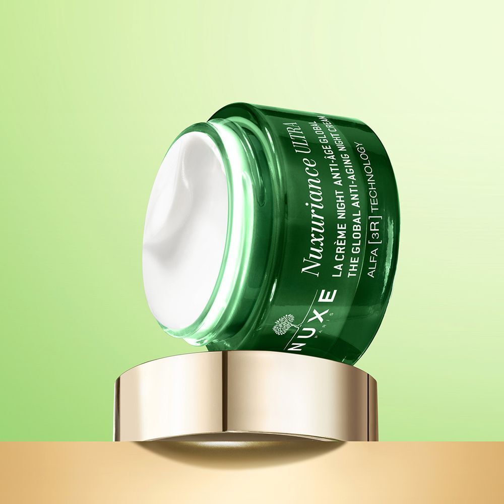 Un vasetto Nuxe Nuxuriance Ultra con crema su un piedistallo dorato.