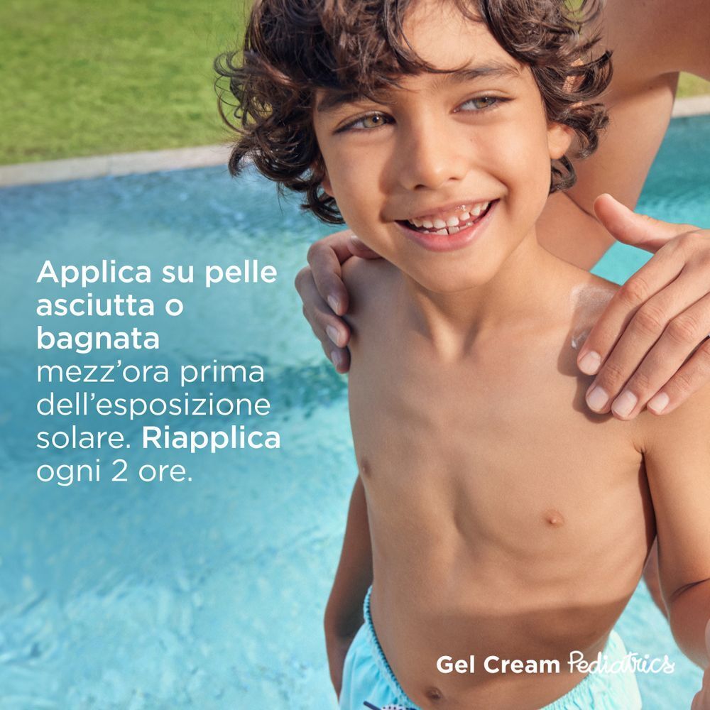 Bambino vicino alla piscina a cui viene applicata la crema solare.