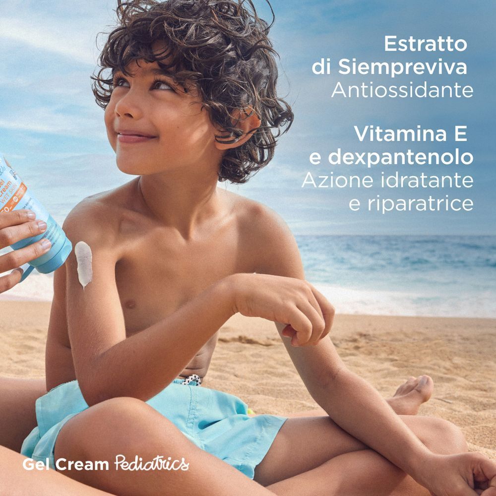 Bambino sulla spiaggia a cui viene applicata la crema solare. Ingredienti menzionati.