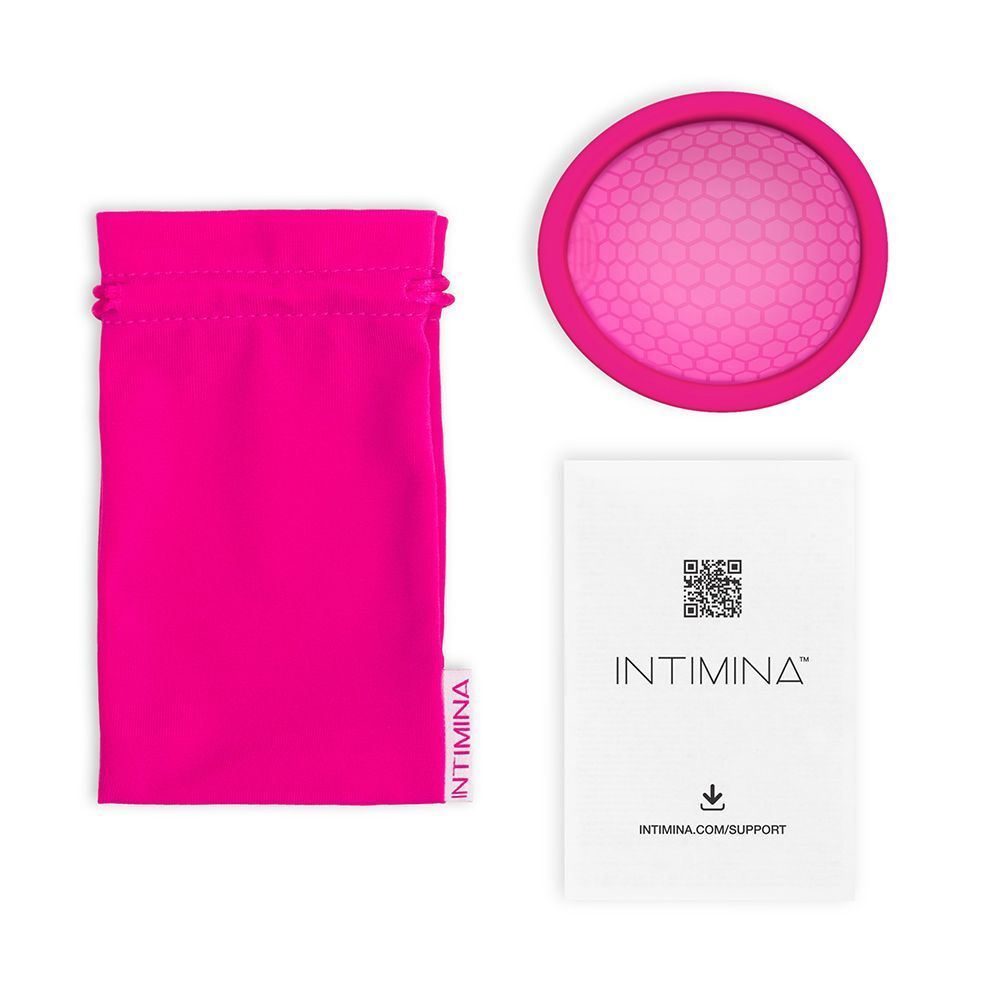 Custodia rosa, una coppetta mestruale e un foglio informativo.