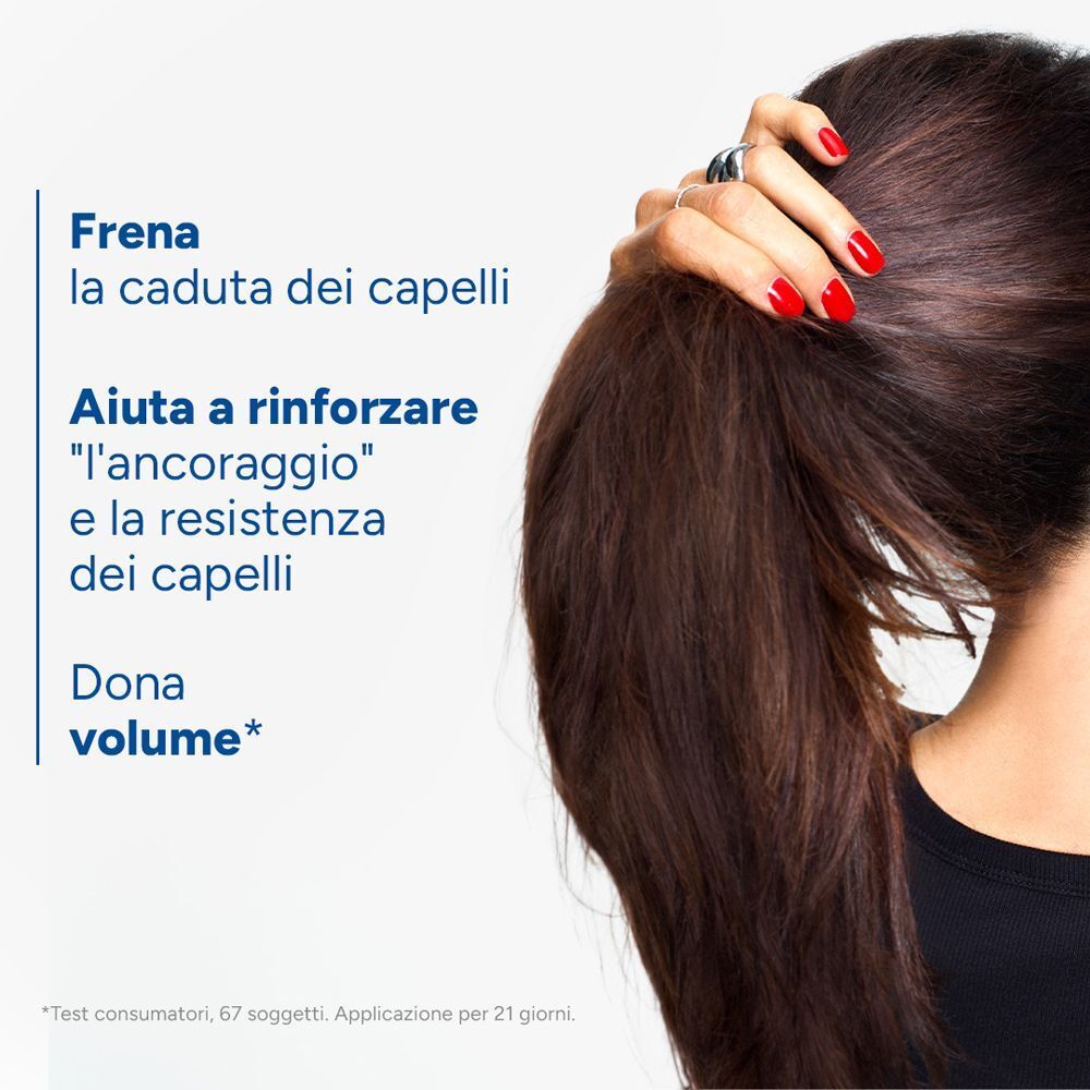 Una donna con capelli lunghi si tiene la coda di cavallo.