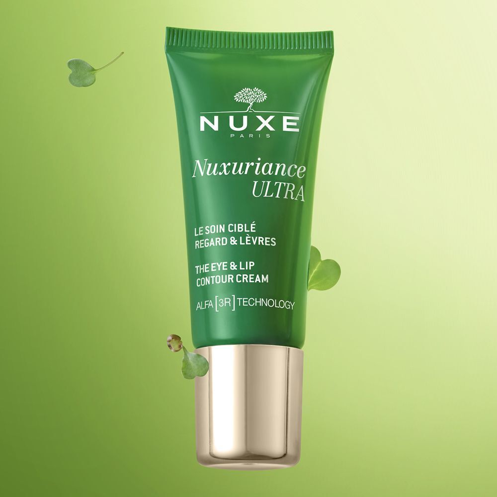 Tubetto verde Nuxe Nuxuriance Ultra crema contorno occhi e labbra, tappo dorato, circondato da foglie.