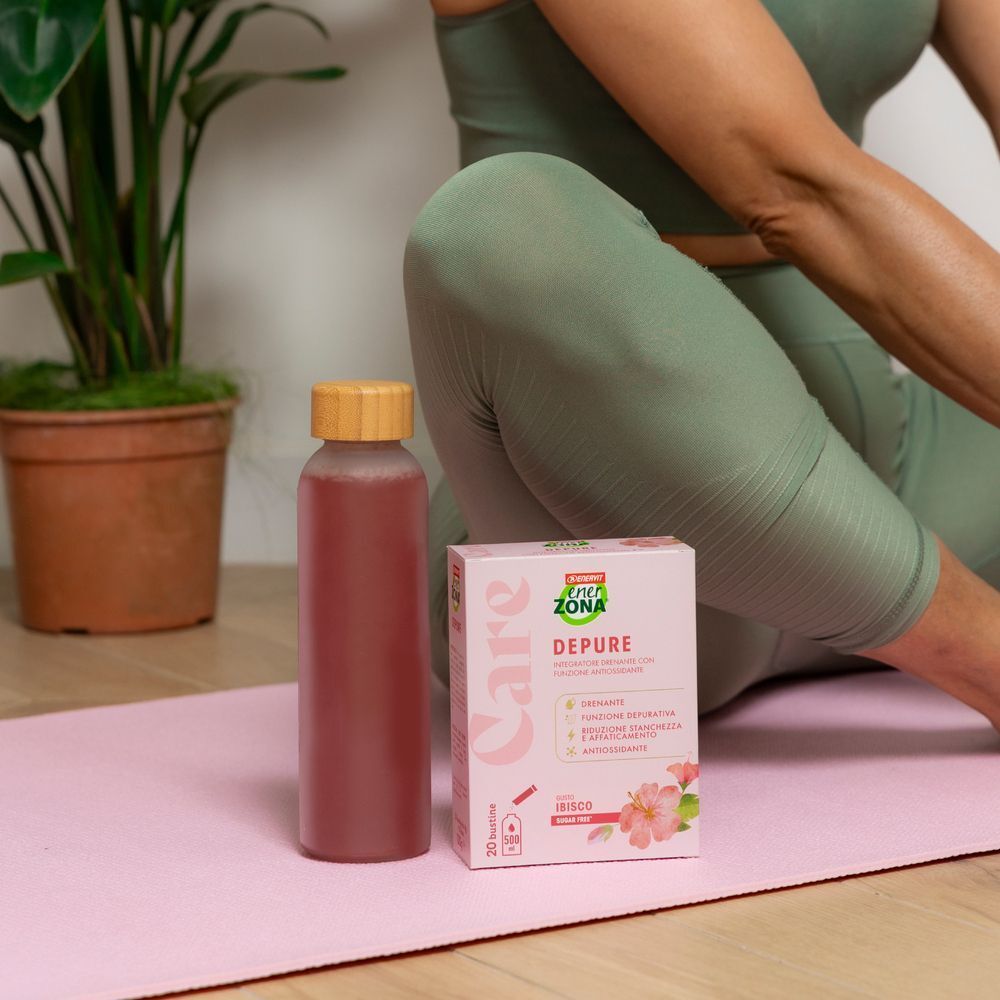 Confezione EnerZona Care Depure e bottiglia su un tappetino da yoga.