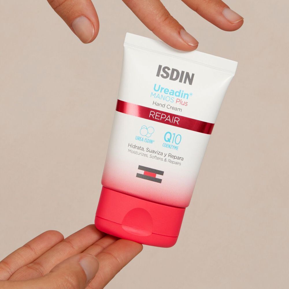 Tubetto di crema mani ISDIN Ureadin Repair tenuto da mani.