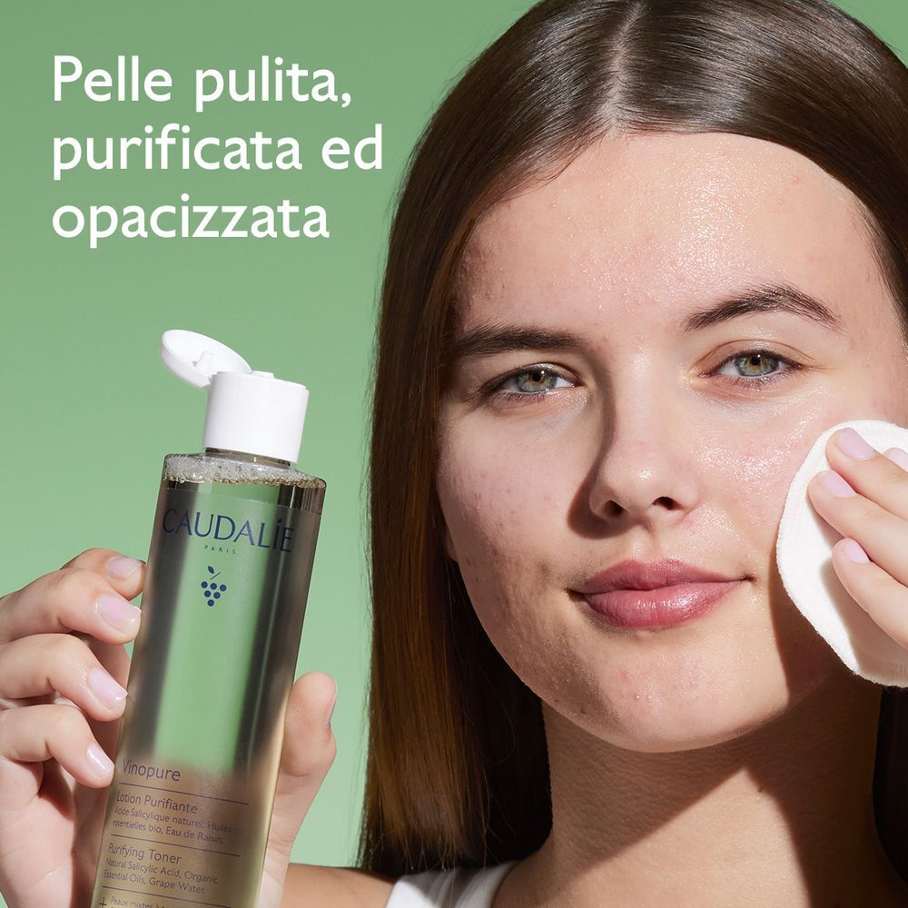 Una donna applica la lozione purificante Caudalie Vinopure su un dischetto di cotone.