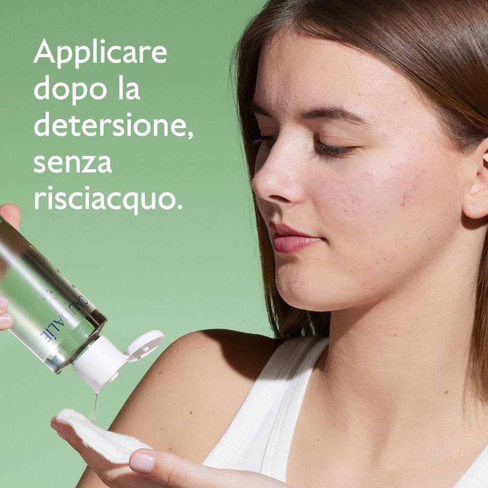 Una donna versa la lozione purificante Caudalie Vinopure su un dischetto di cotone.