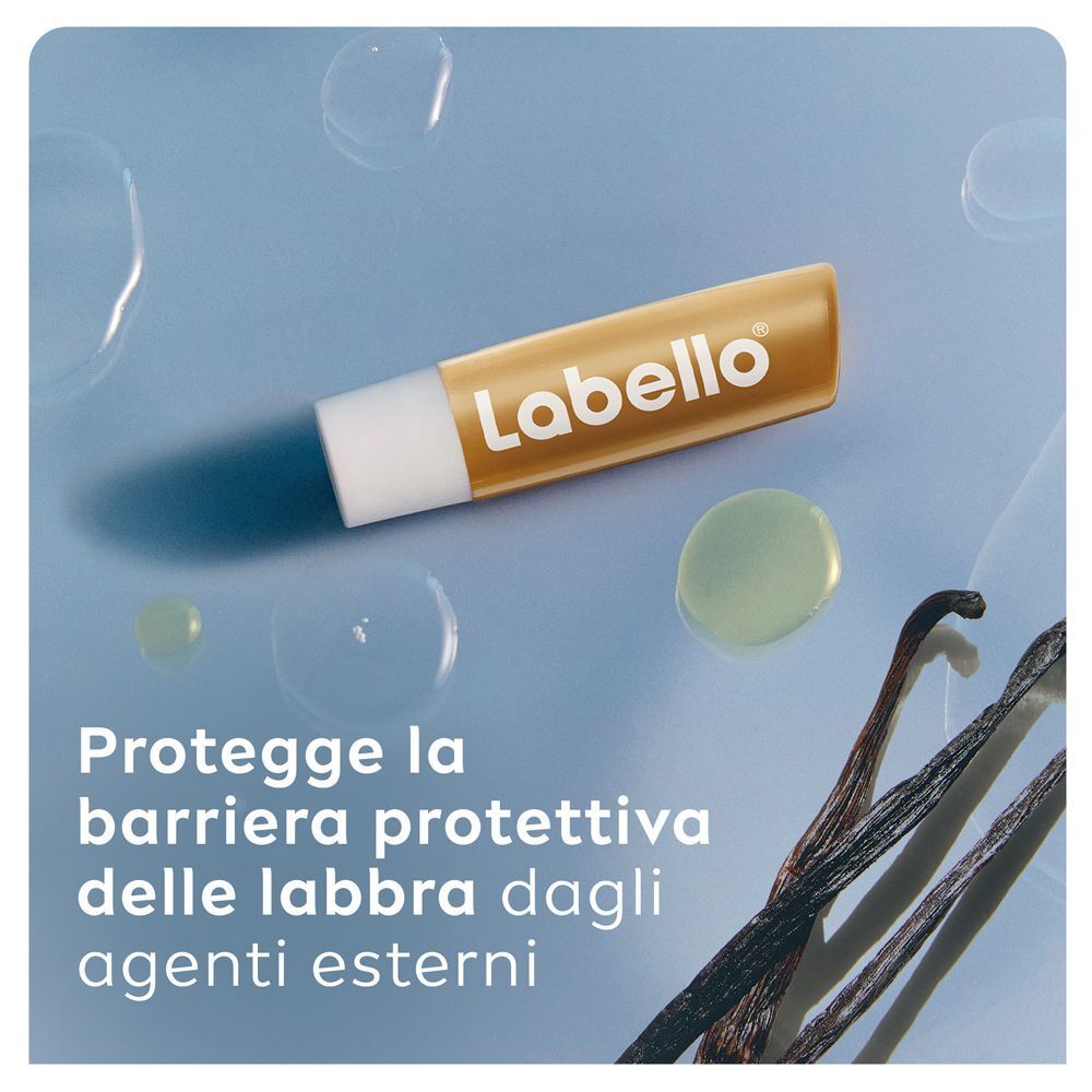 Stick balsamo labbra Labello Vaniglia Buttercream su sfondo blu con baccelli di vaniglia.