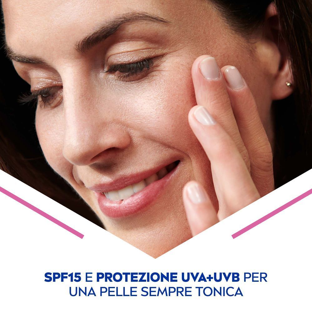 Primo piano di una donna che si tocca la guancia. Protezione SPF15 UVA/UVB per una pelle tonica.