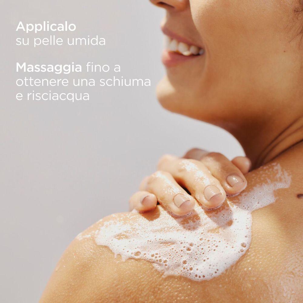 Schiuma sulla spalla di una donna che usa il gel doccia ISDIN Ureadin.