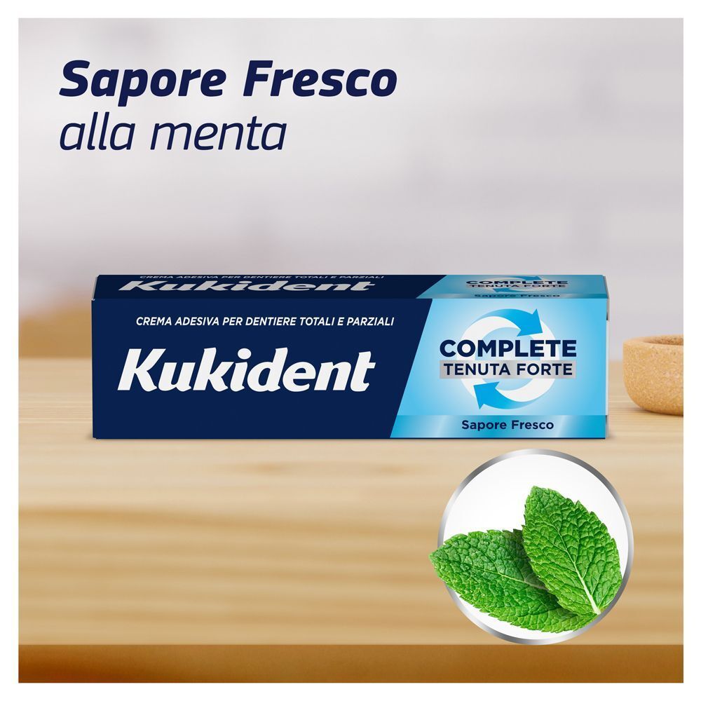 Crema adesiva Kukident Complete con foglie di menta, testo "Sapore Fresco alla menta".