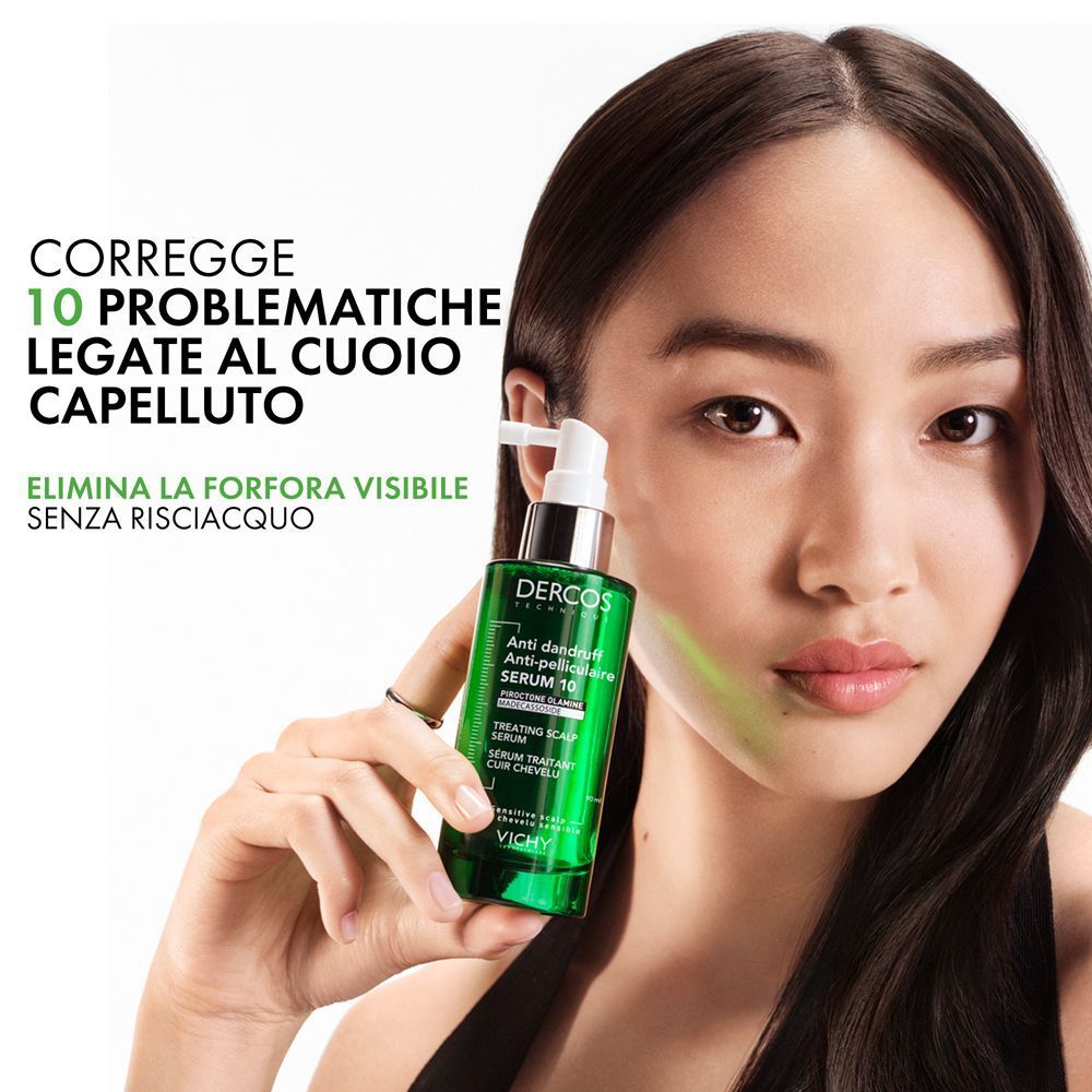 Donna tiene un flacone verde Vichy Dercos Siero Anti-forfora 10, che corregge 10 problematiche del cuoio capelluto.
