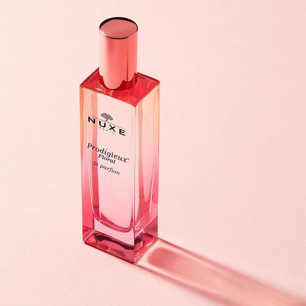 Flacone di Nuxe Prodigieux Floral Le Parfum su sfondo rosa con ombra.