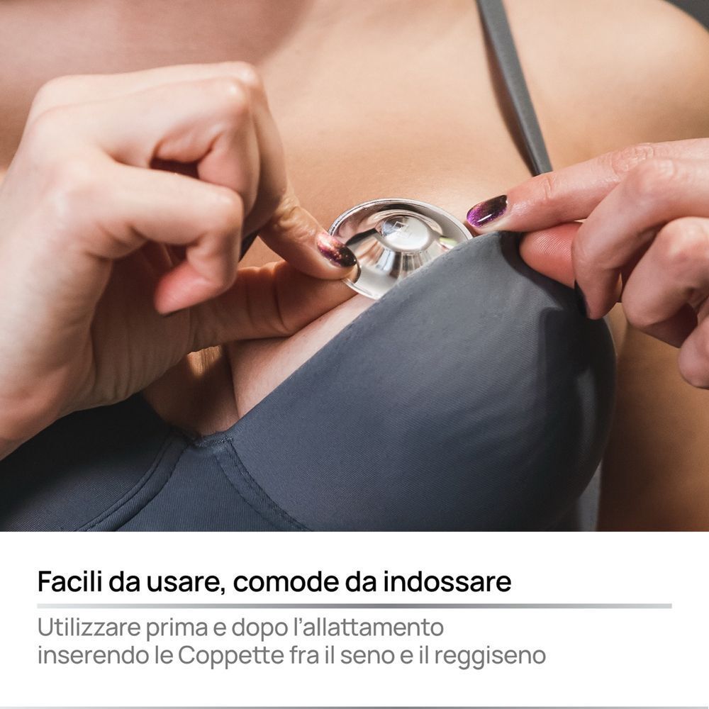 Primo piano: Mani che posizionano le coppette capezzoli COVERbasics Silver Cups in un reggiseno.