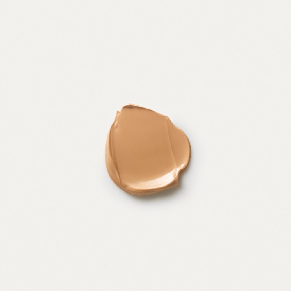 Una macchia di crema trucco beige chiaro su sfondo bianco.