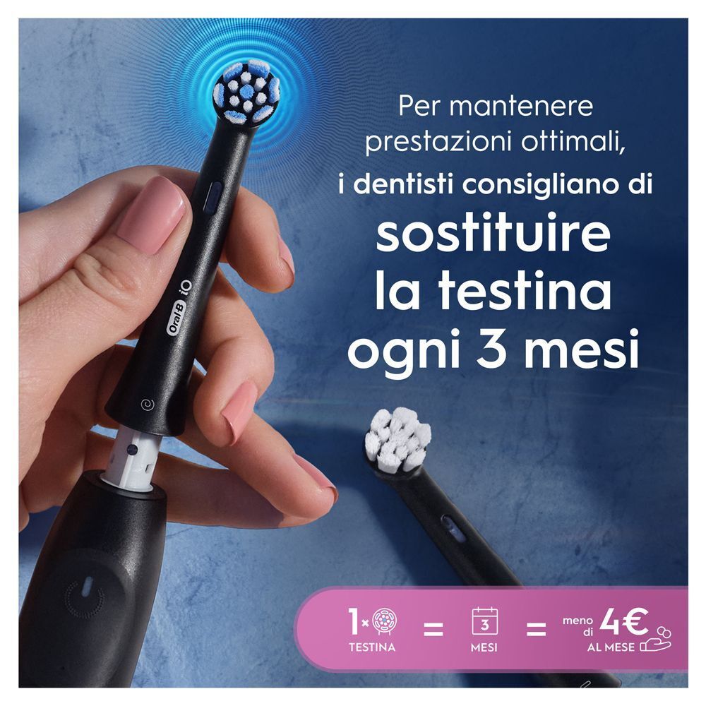 Mano che tiene una testina Oral-B iO, con una testina di ricambio accanto.