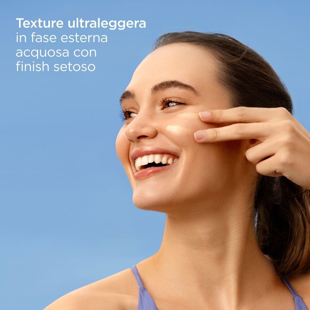 Donna applica ISDIN Fotoprotector Fusion Water Glow SPF50 sulla guancia.