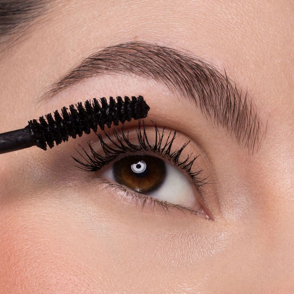 Primo piano di un occhio che riceve un'applicazione di mascara.