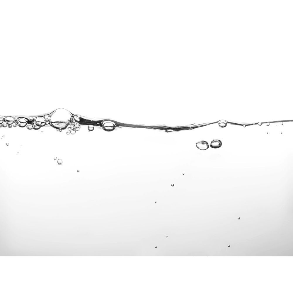 Superficie dell'acqua con bolle d'aria ascendenti su sfondo bianco.