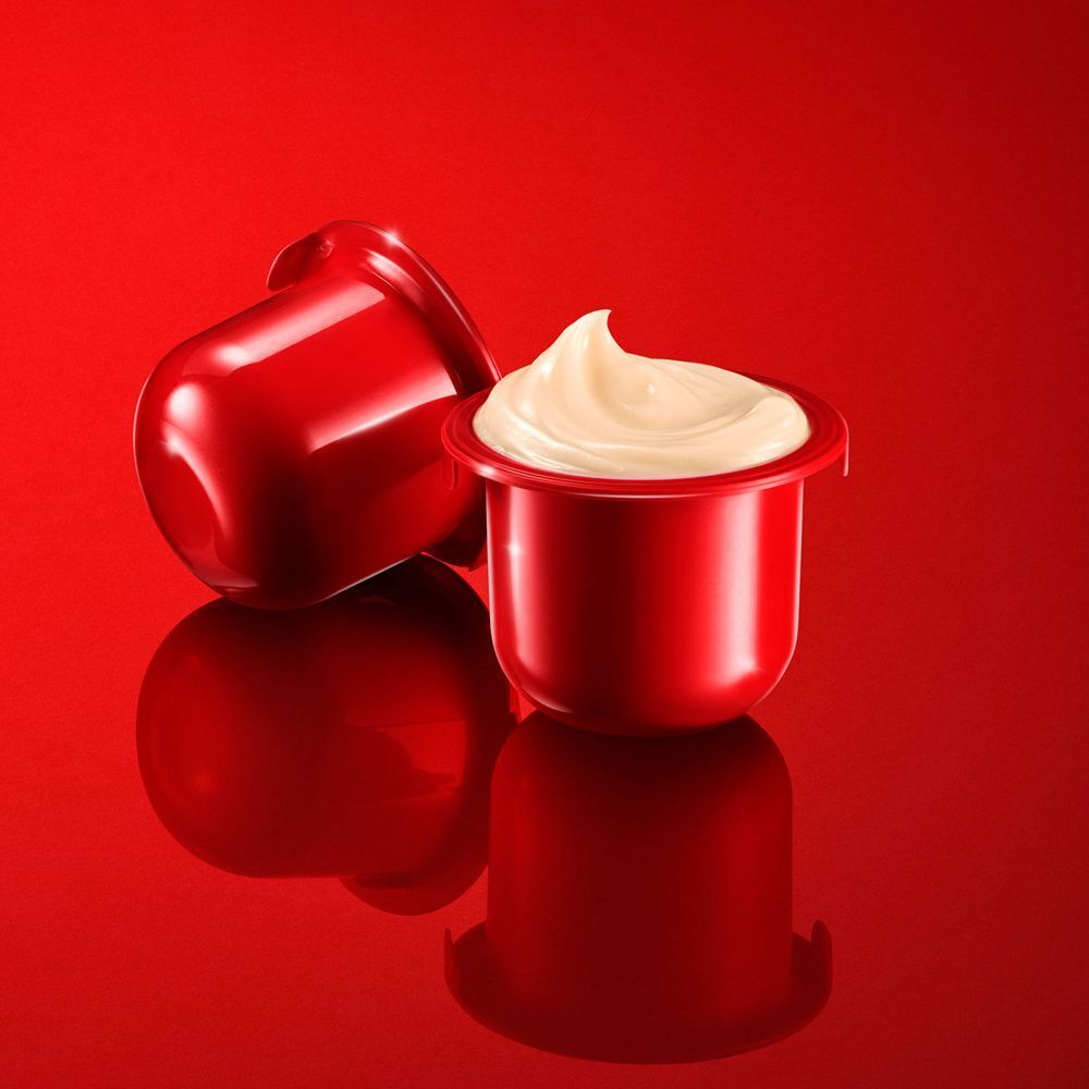 Due capsule ricaricabili rosse per crema viso, una con crema.