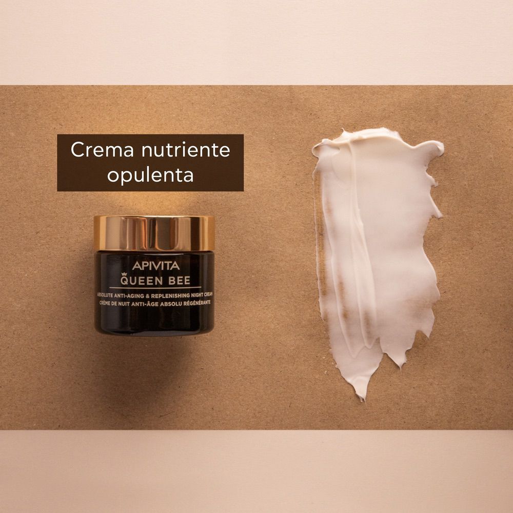 Un vasetto di crema notte APIVITA Queen Bee accanto a un campione di texture cremosa.
