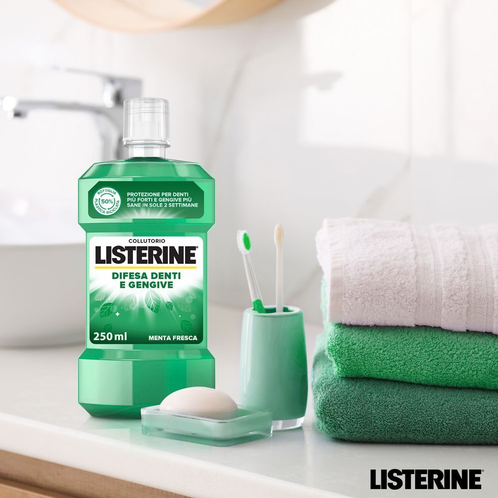 Collutorio Listerine su un lavandino del bagno con asciugamani e spazzolini.