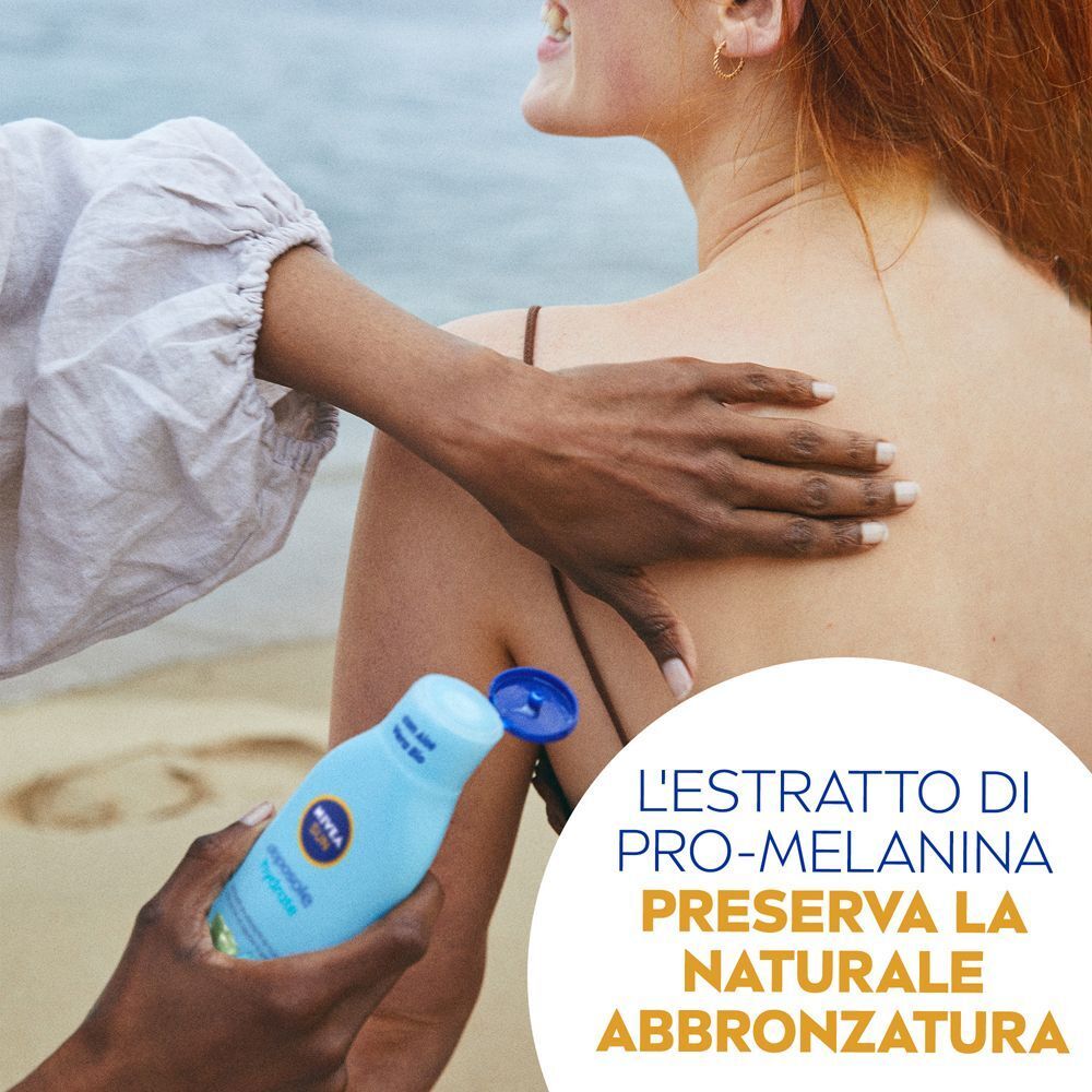 Una mano applica Nivea Sun Latte Doposole Bronze sulla schiena di un'altra persona.