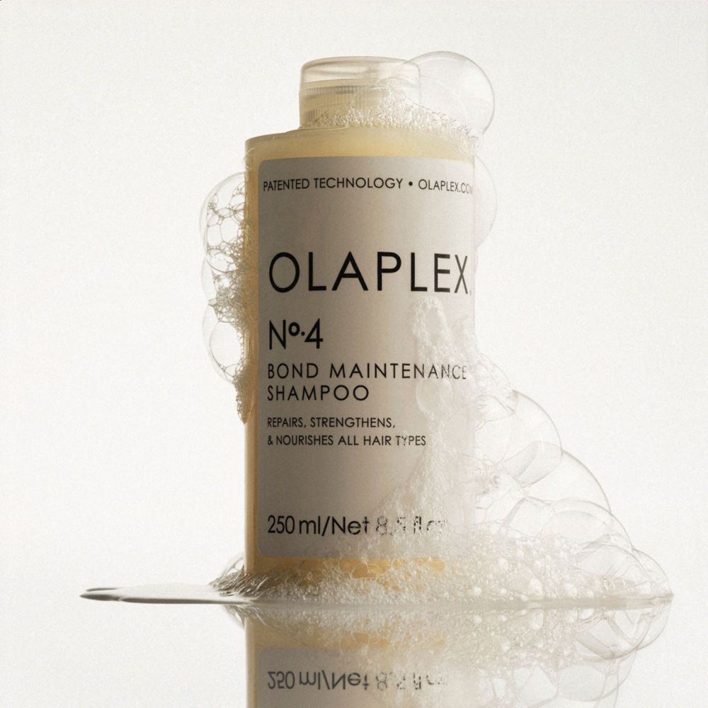 Una bottiglia di Olaplex N°.4 Bond Maintenance Shampoo con schiuma.