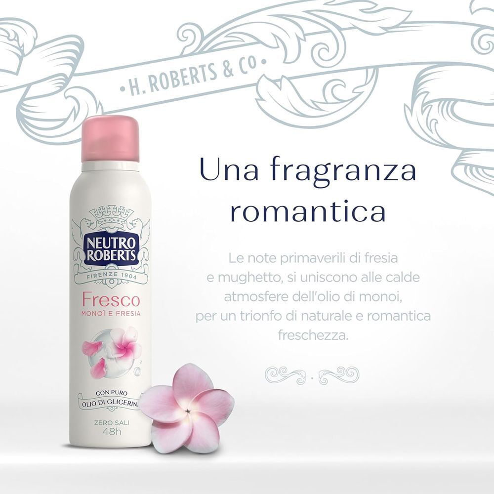 Una bomboletta spray con tappo rosa accanto a un fiore rosa.