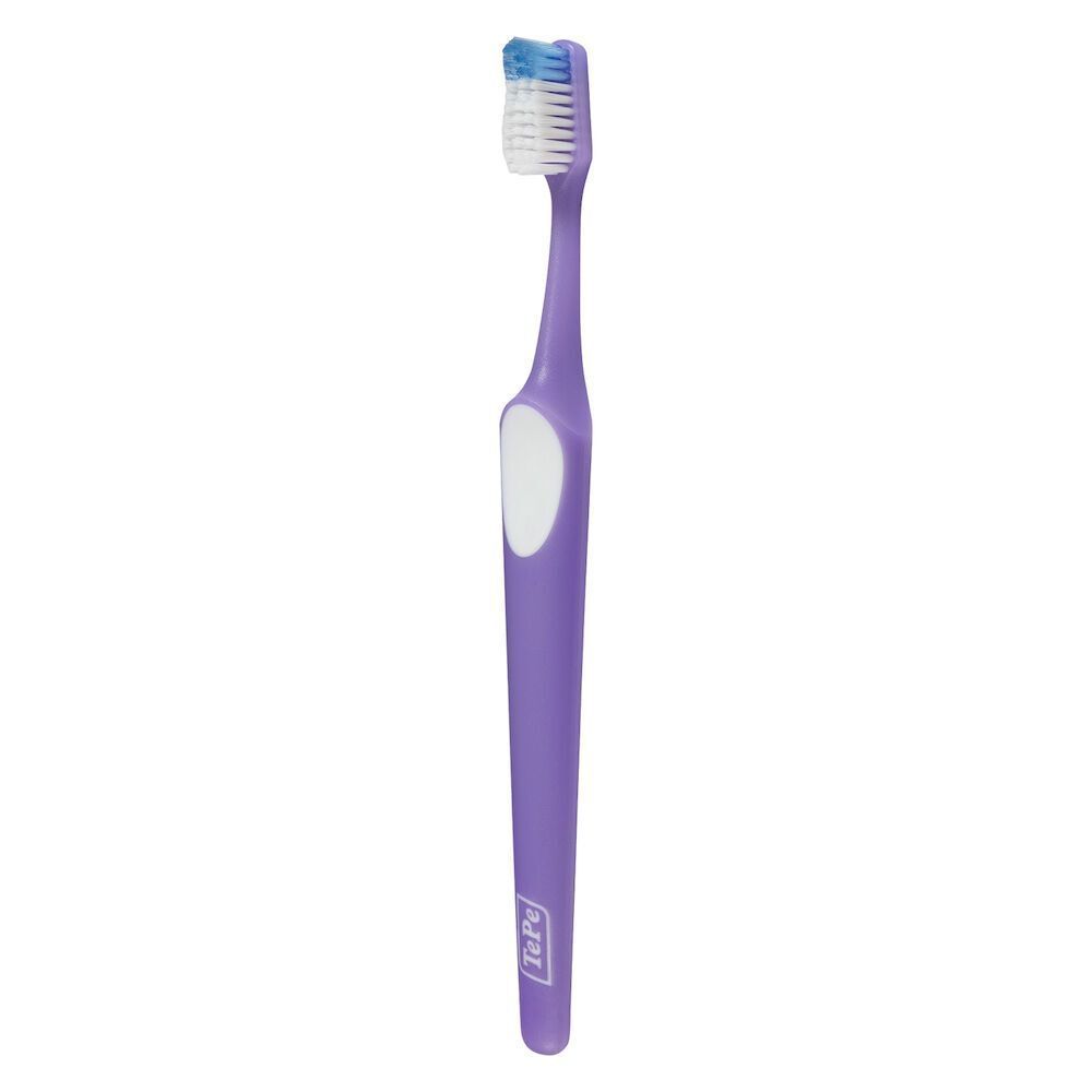 Uno spazzolino TePe Nova™ Medium viola con dettaglio bianco sul manico e setole blu.
