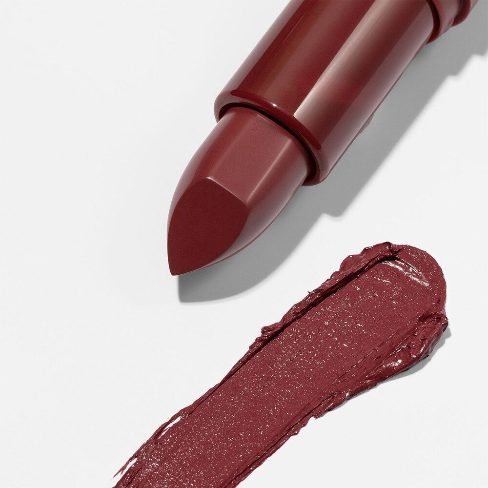 Un rossetto Astra e una striscia di colore rosso su sfondo bianco.