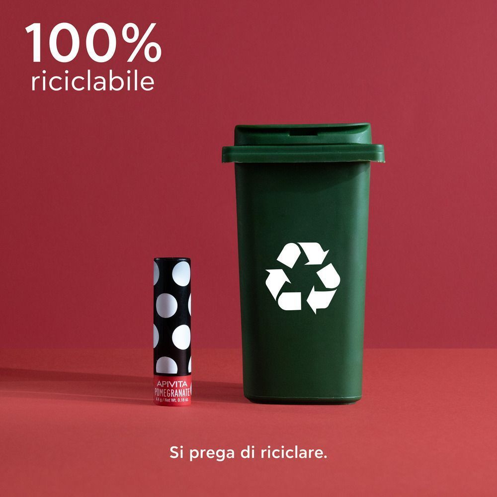 Balsamo labbra accanto a un bidone di riciclaggio verde, 100% riciclabile.