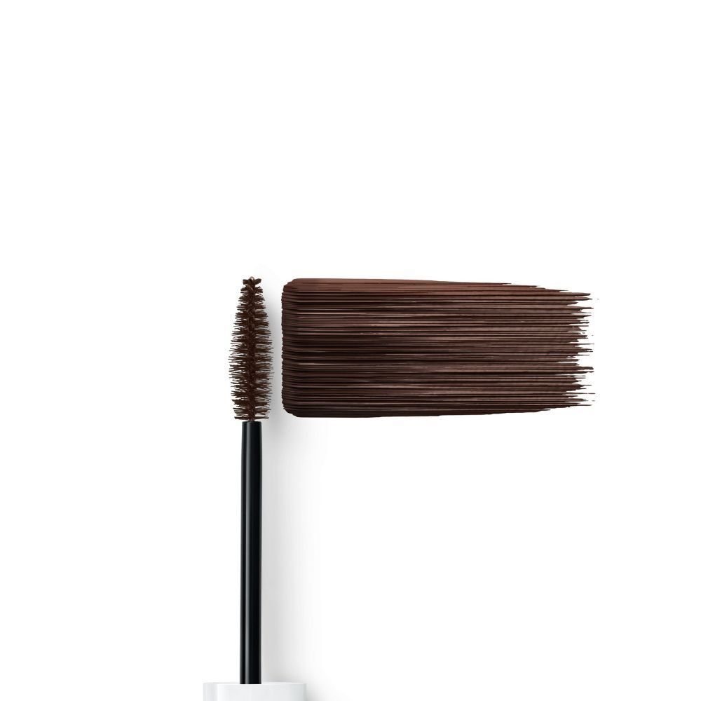 Applicazione di mascara marrone su sfondo bianco, accanto allo scovolino.
