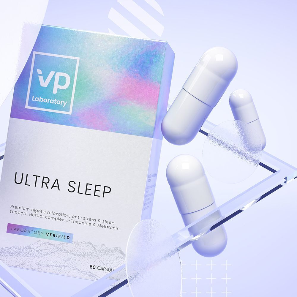 Una scatola VP Laboratory Ultra Sleep accanto a tre capsule su una superficie trasparente.