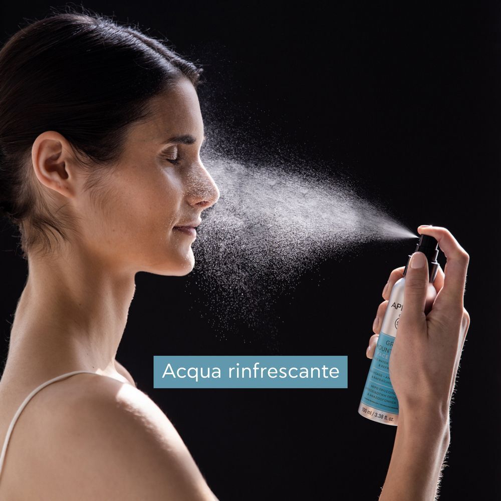Donna si spruzza Acqua Viso APIVITA Tè Greco di Montagna sul viso.